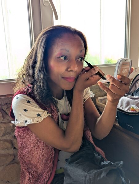 Une comédienne clowne se maquille